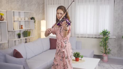Elegant-woman-playing-the-violin-in-the-living-room-at-home-rests-her-soul.